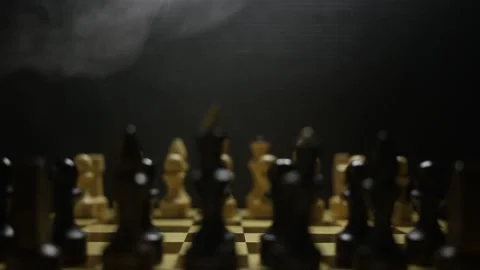 A chess game in sullen shadow with black and white game pieces in smoke Stock Footage 166806361