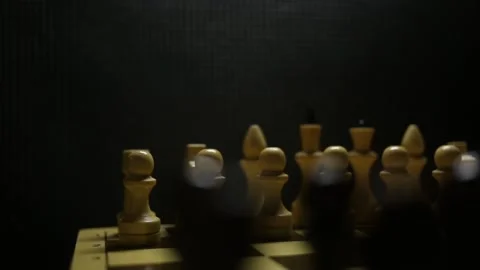 A chess game in sullen shadow with black and white game pieces in smoke. Stock Footage 167041353