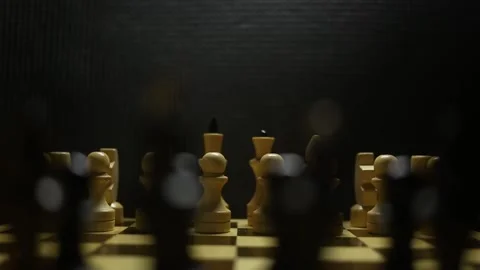 A chess game in sullen shadow with black and white game pieces in smoke. Stock Footage 167041366