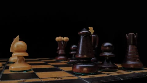 Chess game. A wooden chess pieces on a chess board in lights and shadows. Black Видео 233035053