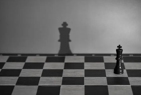Chess King Casting Large Shadow on Board: Concept of Potential and Perception Foto stock