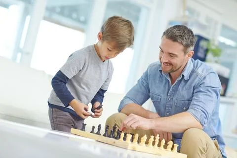 Chess, learning or strategy with father and son in living room together for Foto stock
