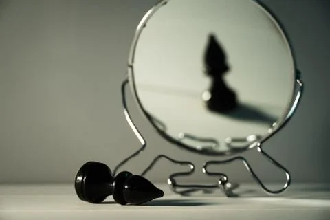 A chess piece is reflected in the mirror. Things and people are not what they 스톡 사진