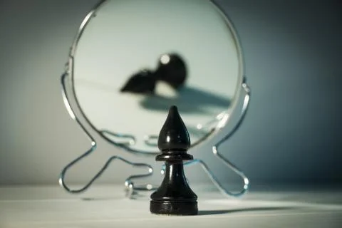 A chess piece is reflected in the mirror. Things and people are not what they Photos