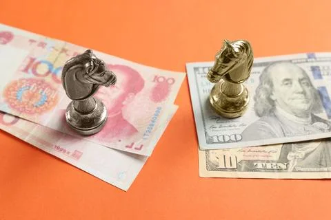 Chess pieces and money on orange background. ChinaUnited States trade war Stock Photos