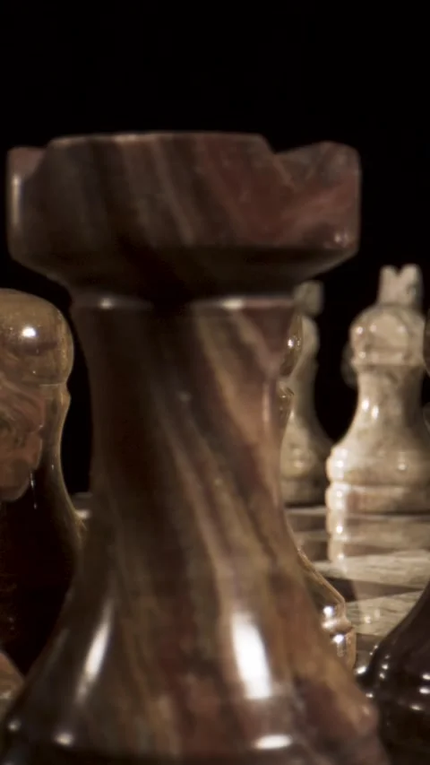 Chess pieces arranged on a board with a dark background Stock Footage 340482702