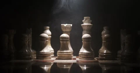 Chess pieces arranged on a board with dramatic lighting in a dark setting Stock Footage 340482512