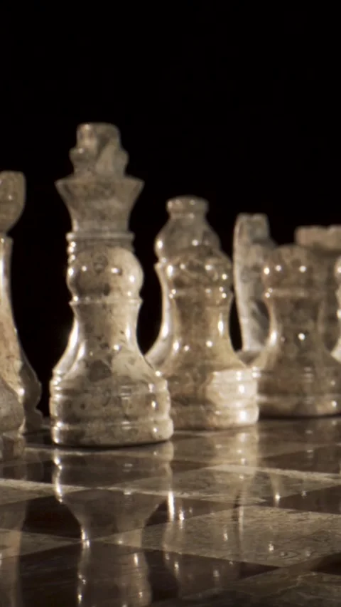 Chess pieces on a board in a dimly lit room Stock Footage 339303590