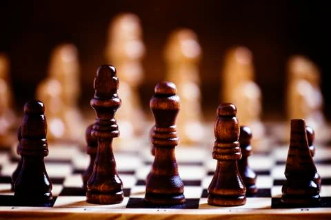 Chess pieces on a chessboard, black background, selective focus, shallow dept Stock Photos