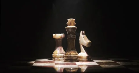 Chess pieces illuminated in dark area during a gaming event Stock Footage 339303559