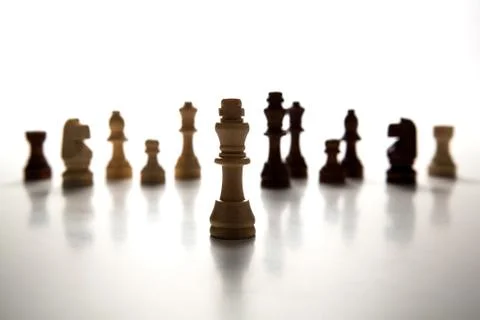 Chess pieces lined up in a row on a gray Stock Photos