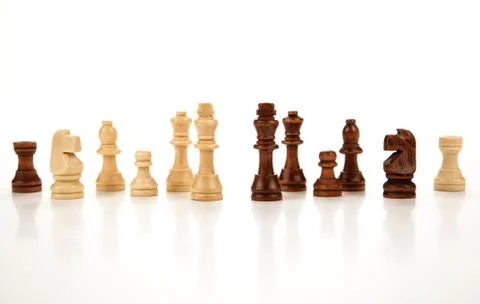 Chess pieces lined up in a row on a gray Stock Photos