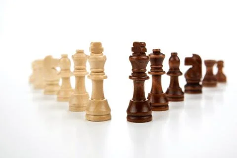 Chess pieces lined up in a row on a gray Stock Photos