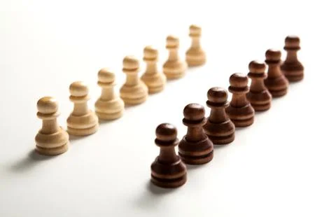 Chess pieces lined up in a row on a white Foto stock