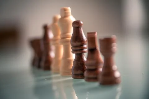 Chess pieces lined up on a table white and black Stock Photos