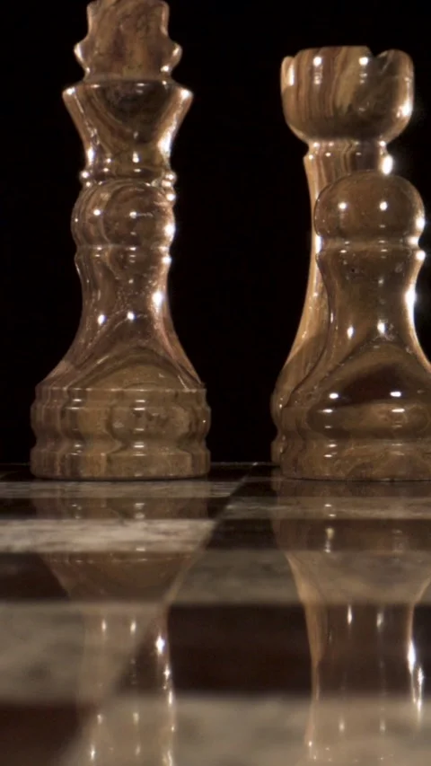 Chess pieces on a marble board with reflections in dim lighting Stock Footage 340482723