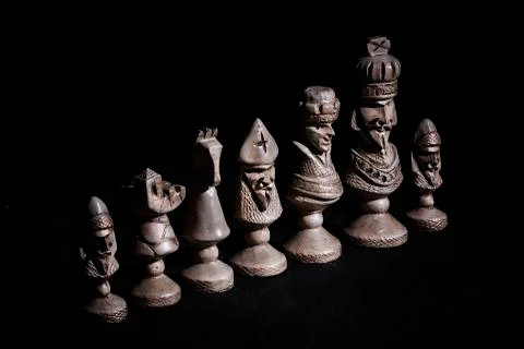 Chess pieces in a row on a black background Stock Photos