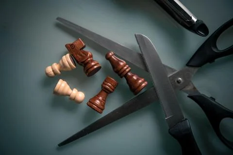 Chess pieces with scissors on a table Stock Photos