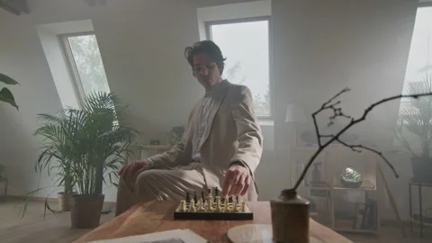 Chess player in elegant coat contemplates strategy in cozy room Stock Footage 319954862