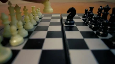 Chess Player Moving White Queen to Attack Black Knight on Board Stockbeeldmateriaal 321398154
