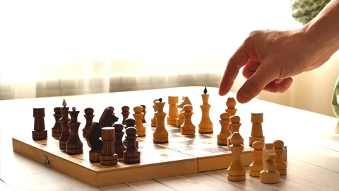 Chess player, a trainer or a father and his son are playing a board game of Stock Footage 123669745