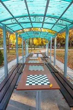 Chess tables under a canopy in a public park. Vertical photo. Stock Photos