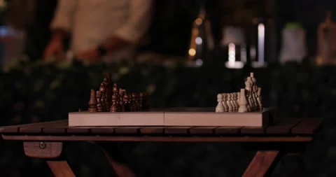 Chessboard table in a coffee shop and a man working in the background Stock Footage 146718737