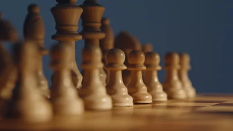 Chessboard white figures closeup under bright sunlight. Pieces tactical force Stock Footage 332337001