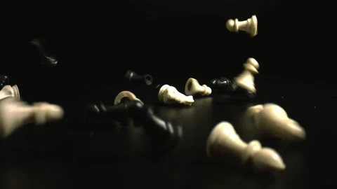 Chessmen falling onto black surface in black background close up. Black and Stock Footage 144342393