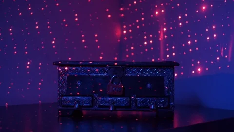 A chest closed on a red combination lock on a table in a dark room with lights. Stock Footage 111700286