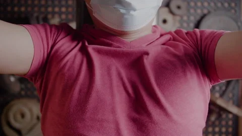 Chest closeup of man wearing face mask bench pressing at home during pandemic Stock Footage 148130100