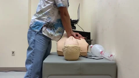 Chest compression CPR first aid practice training class demonstration with audio Stock Footage 156407172