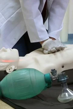 Chest compressions on a simulation dummy during basic life support with an .. Stock Photos