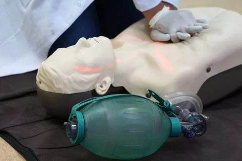 Chest compressions by a student on a simulation dummy during BLS Stock Photos