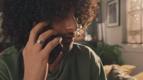 Chest Up Of Curly Young Man Talking By Phone Looking Sad, Bedroom Vidéo 237249817