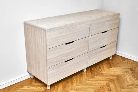 Chest of drawers with bleached solid oak stands on parquet floor Stock Photos