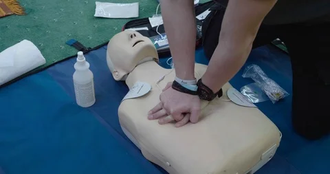 Chest pumping cpr demonstration training on a dummy, closeup Stock Footage 127343532