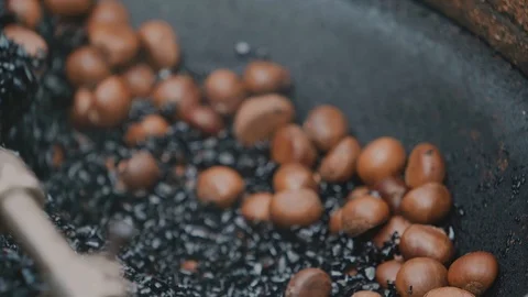 Chestnut roaster, roasting machine made from large wok or built pot Stock Footage 116417691