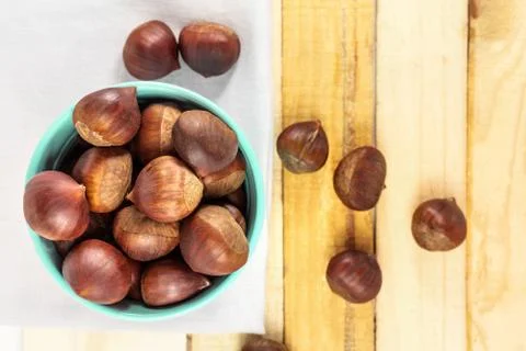 Chestnuts in bucket, on rustic textures with copyspace Stock Photos