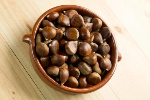 Chestnuts in an earthenware bowl. Stock Photos