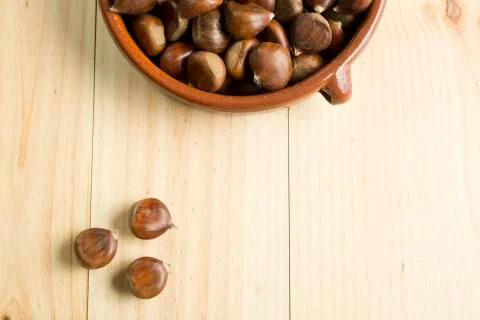 Chestnuts in an earthenware bowl. Stock Photos