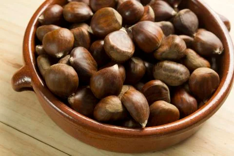 Chestnuts in an earthenware bowl. Stock Photos
