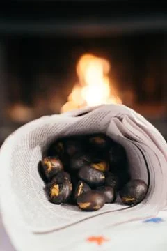 Chestnuts inside a cone with the fireplace in the background. Making roasted  Foto stock