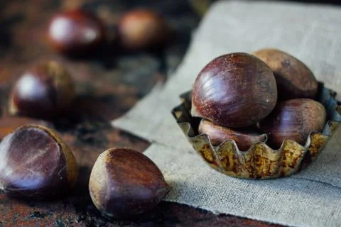Chestnuts over rustic background Stock Photos
