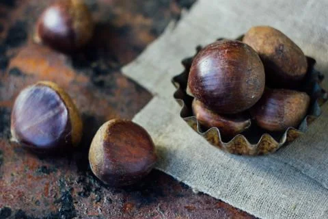 Chestnuts over rustic background Stock Photos