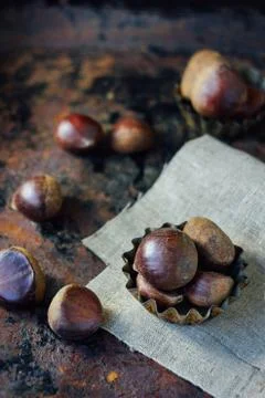 Chestnuts over rustic background Stock Photos