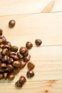 Chestnuts on pine wood background. Stock Photos