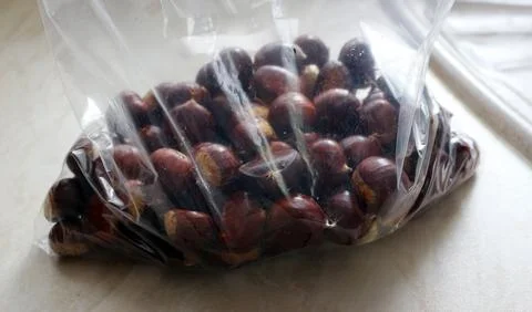 Chestnuts in a plastic bag, close-up, selective focus. Foraged food. Stock Photos