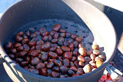 Chestnuts roasted in large pot outside on fire. Useful food and national cuisine Stock Photos