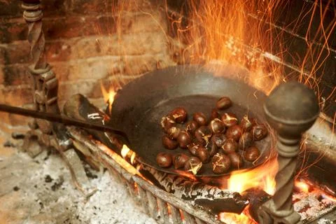 Chestnuts roasting on an open fire. Stock Photos
